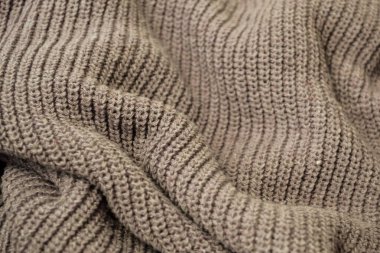 Buruşuk kahverengi örülmüş süveter.