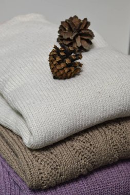 Ilık süveter yığınının üzerinde iki koni var.