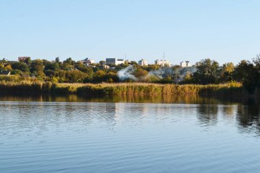 Beyaz dumanın görülebildiği göl ve kıyı manzarası