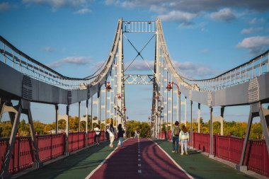 İnsanlar sonbaharda köprüde yürür.