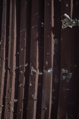 Çitte roket parçalarından delikler var.