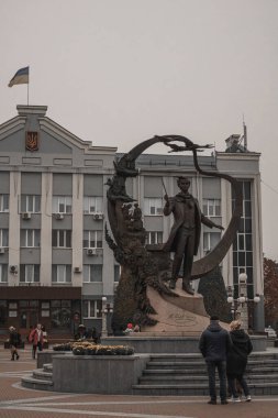 İnsanlar şairin anıtına bakar.