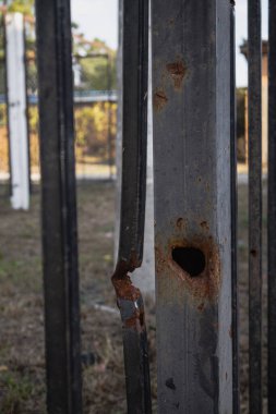 Metal çit roketin şarapneli tarafından delinmiş.