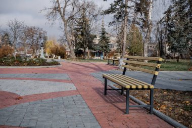 Parkın ortasında banklar var ve sonbaharın sonunda güzelce temizleniyor.