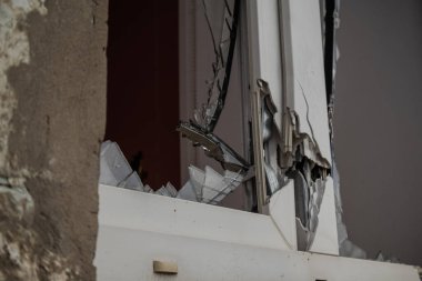 Izyum, Ukrayna - 10 Kasım 2023. Pencere kırılmış ve çerçeveden dışarı sarkan camlar görünüyor.