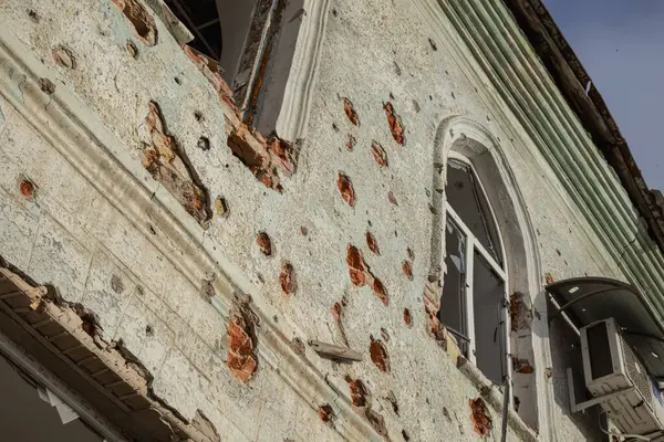 stock image Izyum, Ukraine - November 10, 2023, in the center of the city there is a building without windows and with holes in the wall from shrapnel