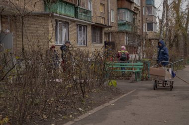 Kyiv, Ukrayna - 26 Kasım 2023: Bir ev insansız hava aracı şarapneli tarafından hasar gördükten sonra insanlar bahçeyi temizliyor