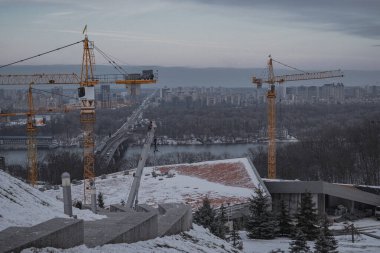 Kyiv, Ukrayna. 28 Kasım 2023: İnşaat vinçlerinin inşaatı Dnipro Nehri yakınlarında sürüyor
