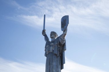 Kyiv, Ukrayna. 30 Kasım 2023: Anavatan anıtı mavi gökyüzü arkaplanına karşı bir kalkanda mızrak ile