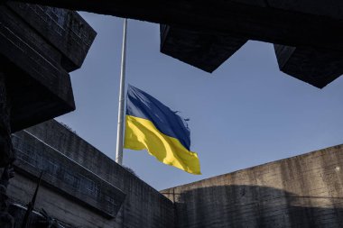 Kyiv, Ukrayna. 30 Kasım 2023: Mavi gökyüzü ve Ukrayna bayrağı beton duvarların arasından görülebilir.