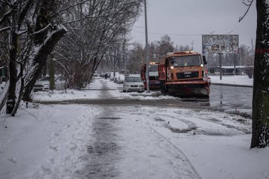 Kyiv, Ukrayna. 01.12.2023: Bir araba şehrin içinden geçiyor ve karı temizliyor.