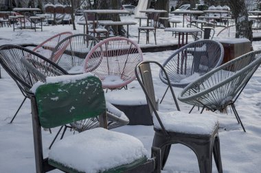 KYIV, UKRAINE - 6 ARALIK 2023 VDNG TÜRKESİ 'nde kar kaplı sandalyeler var çünkü kafe kapalı..