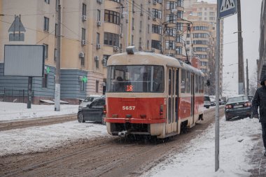 KYIV, UKRAINE - 8 ARALIK 2023: çok sabahtan beri kar yağışlı. GERÇEK Kışlar başladı. İnsanlar işe gider ve arabaları yanından geçirir. Bazen trajediler de olur. SLIPPERY YOLU.