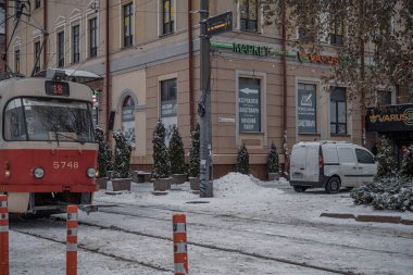 KYIV, UKRAINE - 8 ARALIK 2023: çok sabahtan beri kar yağışlı. GERÇEK Kışlar başladı. İnsanlar işe gider ve arabaları yanından geçirir. Bazen trajediler de olur. SLIPPERY YOLU.