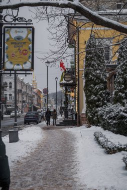 KYIV, UKRAINE - 8 ARALIK 2023 Sabahtan beri, şehir kar altında. Yollar kaygandır, ama insanlar kendi işleriyle ilgilenmeye başlarlar. ŞEHRİ YILI YIL İÇİN BİR YIL ÖNCE.