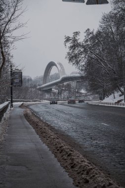 KYIV, UKRAINE - 8 ARALIK 2023: çok sabahtan beri kar yağışlı. GERÇEK Kışlar başladı. İnsanlar işe gider ve arabaları yanından geçirir. Bazen trajediler de olur. SLIPPERY YOLU.
