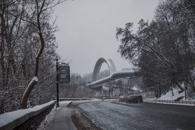 KYIV, UKRAINE - 8 ARALIK 2023: çok sabahtan beri kar yağışlı. GERÇEK Kışlar başladı. İnsanlar işe gider ve arabaları yanından geçirir. Bazen trajediler de olur. SLIPPERY YOLU.