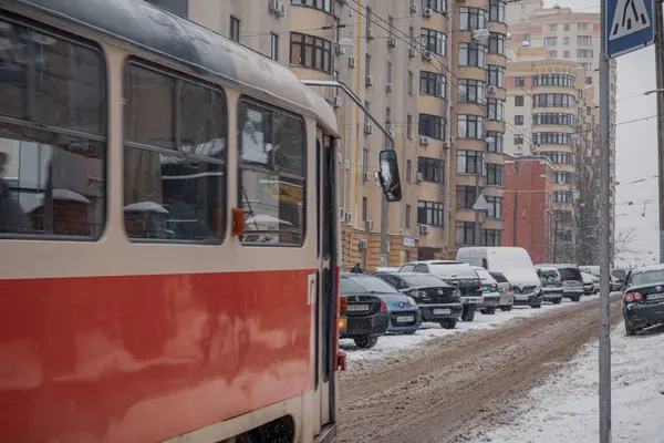 KYIV, UKRAINE - 8 ARALIK 2023: çok sabahtan beri kar yağışlı. GERÇEK Kışlar başladı. İnsanlar işe gider ve arabaları yanından geçirir. Bazen trajediler de olur. SLIPPERY YOLU.