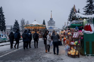 Kyiv, Ukrayna - 12 Aralık 2023: soğuk havada, aileler ve arkadaşlar VDNG 'de toplanıyor, orada yeni yıl fuarı açıldı. Yürüyüşe çıkarlar, sıcak kahve içerler ve ata binerler..