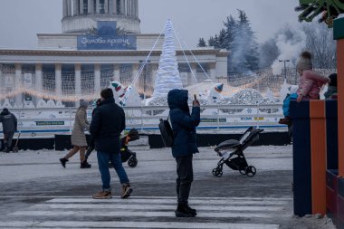 Kyiv, Ukrayna - 12 Aralık 2023: soğuk havada, aileler ve arkadaşlar VDNG 'de toplanıyor, orada yeni yıl fuarı açıldı. Yürüyüşe çıkarlar, sıcak kahve içerler ve ata binerler..