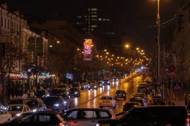 Kyiv, Ukrayna - 22 Aralık 2023: Khreschatyk 'teki Kyiv' in merkezinde Merkez Alışveriş Merkezi dekore edildi. Akşamları, çok güzel parlıyor. İnsanlar yürüyor ve yakınlarda arabalar sürüyor..