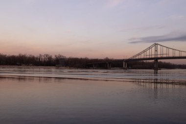 Kyiv, Ukrayna - 20 Aralık 2023: Noel 'den önceki kış akşamı, Dnipro Nehri' ne düşen güzel bir günbatımı vardı.