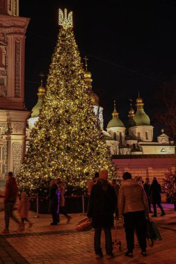 Kyiv, Ukrayna - 20 Aralık 2023: Yılbaşı akşamı Sofiyivska Ploscha 'daki Kyiv' in merkezindeki Noel ağacına insanlar gelir. Çocukları getir ve sıcak kahve iç..