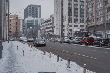KYIV, UKRAINE - 8 ARALIK 2023: çok sabahtan beri kar yağışlı. GERÇEK Kışlar başladı. İnsanlar işe gider ve arabaları yanından geçirir. Bazen trajediler de olur. SLIPPERY YOLU.
