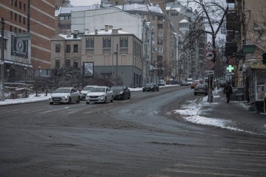 KYIV, UKRAINE - 8 ARALIK 2023: çok sabahtan beri kar yağışlı. GERÇEK Kışlar başladı. İnsanlar işe gider ve arabaları yanından geçirir. Bazen trajediler de olur. SLIPPERY YOLU.