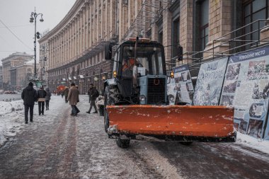 Kyiv, Ukrayna - 8 Aralık 2023: Sabah şiddetli kar yağıyordu ve temizlik ekipmanları şehre giriyordu. Ve insanlar karları temizliyor. Traktörler khreschatyk 'te kardan kaldırımı temizler.