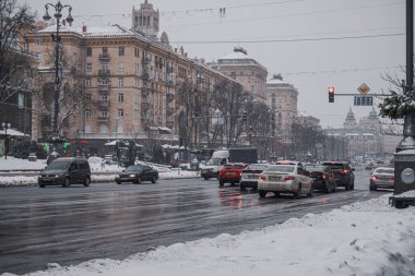 KYIV, UKRAINE - 8 ARALIK 2023: çok sabahtan beri kar yağışlı. GERÇEK Kışlar başladı. İnsanlar işe gider ve arabaları yanından geçirir. Bazen trajediler de olur. SLIPPERY YOLU.