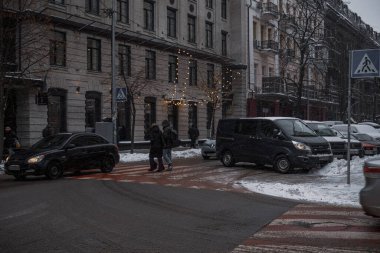 Kyiv, Ukrayna - 8 Aralık 2023: Sabah şiddetli kar yağıyordu ve temizlik ekipmanları şehre giriyordu. Ve insanlar karları temizliyor. Traktörler ayakta ve insanlar zaten temiz olan kaldırımda duruyorlar.