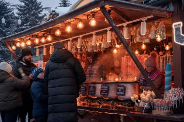 Kyiv, Ukrayna - 12 Aralık 2023: İnsanlar yeni yıl fuarına dinlenmek ve ızgarada taze yapılmış sokak yemekleri yemek için geldiler. Gerçek bir yiyecek ve içecek fuarı açıldı. İnsanlar sohbet eder ve dolaşır..