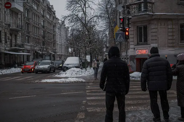 KYIV, UKRAINE - 8 ARALIK 2023: çok sabahtan beri kar yağışlı. GERÇEK Kışlar başladı. İnsanlar işe gider ve arabaları yanından geçirir. Bazen trajediler de olur. SLIPPERY YOLU.