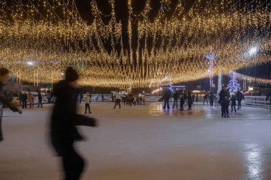Kyiv, Ukrayna - 26 Aralık 2023: VDNG 'de her şey yeni yıl için dekore edildi. Bir sürü insanın kaydığı pistler ve buz pateni pistleri var. Üzerinde güzel, parlak çelenkler asılı.