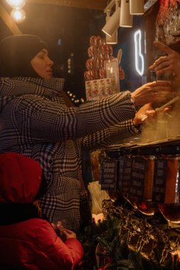 Kyiv, Ukrayna - 26 Aralık 2023: Kyiv 'de, ailesi ve arkadaşları olan herkes Noel' i kutlamaya geldi. Yılbaşı tezgahlarında çeşitli yiyecekler, sıcak içecekler ve geleneksel yemekler satılıyor..