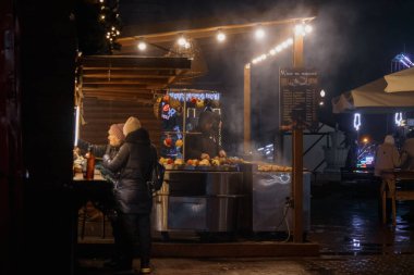 Kyiv, Ukrayna - 26 Aralık 2023: Kyiv 'de, ailesi ve arkadaşları olan herkes Noel' i kutlamaya geldi. Yılbaşı tezgahlarında çeşitli yiyecekler, sıcak içecekler ve geleneksel yemekler satılıyor..