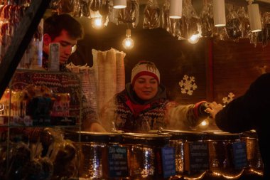 Kyiv, Ukrayna - 26 Aralık 2023: Kyiv 'de, ailesi ve arkadaşları olan herkes Noel' i kutlamaya geldi. Yılbaşı tezgahlarında çeşitli yiyecekler, sıcak içecekler ve geleneksel yemekler satılıyor..