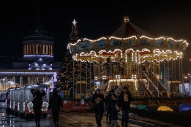 Kyiv, Ukrayna - 26 Aralık 2023: VDNG 'de yeni yıl hikayesi yaratıldı. Noel ağacı süslenmiş, bir sürü atlıkarınca ve yiyecek tezgahı var. İnsanlar Noel 'i kutlamaya geldi.