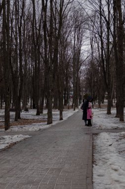Kyiv, Ukrayna - 20 Ocak 2024: Borshchagivka 'nın rahat uyku bölgesi. İnsanlar boş günlerinde parkta yürüyorlar. Yunist Park 'ta bir sürü farklı ağaç var. konut binalarının yanında yer almaktadır
