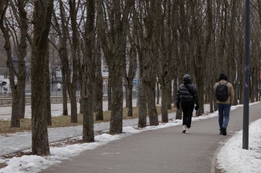 Kyiv, Ukrayna - 20 Ocak 2024: Borshchagivka 'nın rahat uyku bölgesi. İnsanlar boş günlerinde parkta yürüyorlar. Yunist Park 'ta bir sürü farklı ağaç var. konut binalarının yanında yer almaktadır