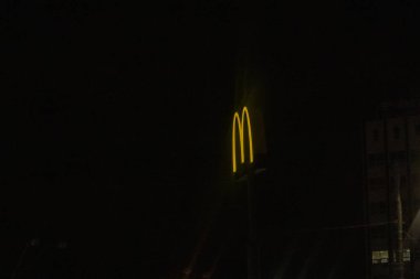 Kyiv, Ukrayna - 3 Şubat 2024. Akşam işten sonra insanlar evde yemek pişirmemek için sık sık McDonald 's' a bir şeyler yemeye giderler. İşaret sarıyla aydınlatılmış. Herkesin zamanı varmış gibi çalışıyor..