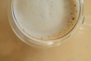 Kyiv, Ukrayna - 30 Ocak 2024: Güneşli bir kış sabahı, güzel giyinen kızlar kendilerine sıcak kahve yapıp kahvaltı yaptılar. Kızın kalbi olan ılık beyaz pijamaları var.