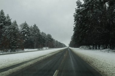 Kyiv, Ukrayna - 3 Şubat 2024. Sokakta şiddetli kar yağıyor, yollar karla kaplı. Güzel karlı orman ve tarlalar. Kyiv 'den başka bir şehre giden yol. Ormanın ve tarlaların muhteşem manzarası