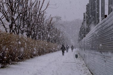 Kyiv, Ukrayna - 10 Şubat 2024, kasvetli ve gri hava. Biraz kar yağıyor. Şehir beyaz karla gizlenmiş. İnsanlar dışarıda yürüyor. Şehrin mimarisi karla kaplıdır.