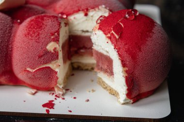 Kyiv, Ukrayna - 5 Şubat 2024 güzel mus, küçük toplar şeklinde kırmızı pasta. Üstünde beyaz çikolata çiçekleri var. Doğum günüm için bana pasta verdiler. Pasta siyah bir masanın üzerinde duruyor. lezzetli ahududu aromalı.