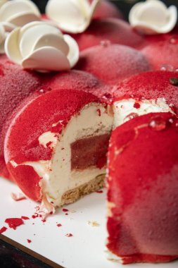 Kyiv, Ukrayna - 5 Şubat 2024 güzel mus, küçük toplar şeklinde kırmızı pasta. Üstünde beyaz çikolata çiçekleri var. Doğum günüm için bana pasta verdiler. Pasta siyah bir masanın üzerinde duruyor. lezzetli ahududu aromalı.