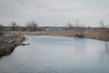 Irpin, Ukrayna. 26 Şubat 2024 sabahı, kış sonunda hava çok sıcaktı. İnsanlar gölün yakınındaki parklarda yürüyorlar. Şehrin merkezindeki güzel ormanlar.