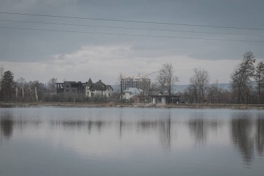 Ivano-Frankivsk, Ukrayna. 28 Şubat 2024, küçük bir Avrupa şehri. Şubatın sonunda, hava çok sıcak, insanlar göl kenarında yürüyorlar. Kuşları besle ve spor yap.