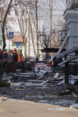 Kyiv, Ukrayna. 21 Mart 2024 sabahı erken saatlerde Ruslar şehre füze fırlattı. Hasarlı evler, arabalar ve yolda bir çukur. İnsanlar temizliğe yardım etmeye geldi..